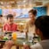 A family of 4 enjoying a meal at Gramma Tala’s Kitchen on the Disney Adventure cruise ship